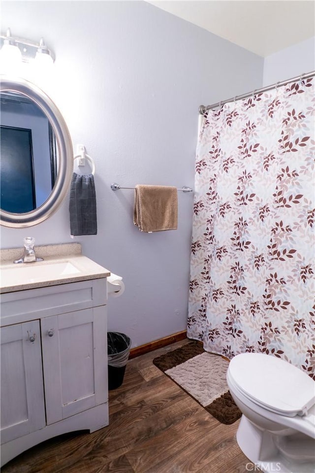 bathroom with vanity, toilet, and hardwood / wood-style floors