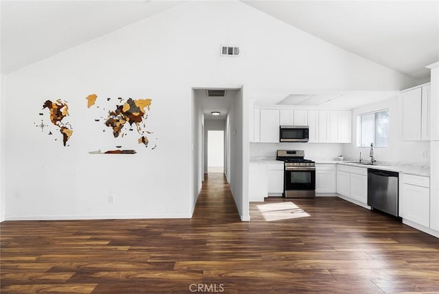 kitchen with high vaulted ceiling, white cabinets, sink, dark hardwood / wood-style floors, and appliances with stainless steel finishes