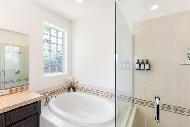 bathroom featuring vanity and independent shower and bath