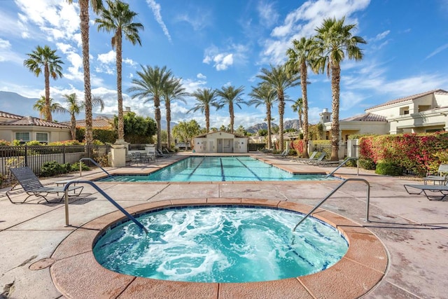 view of swimming pool with a hot tub and a patio