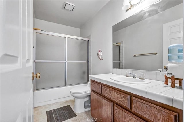 full bathroom with tile patterned flooring, vanity, toilet, and enclosed tub / shower combo