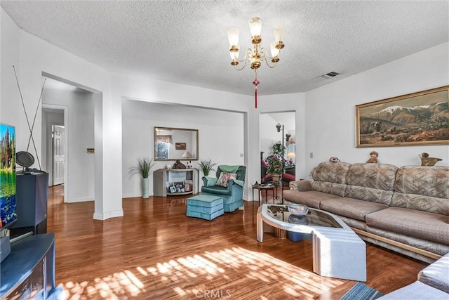 living room with a chandelier, wood-type flooring, and a textured ceiling