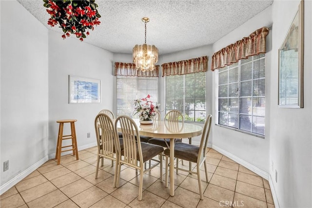 dining space featuring light tile patterned floors, a textured ceiling, and a chandelier