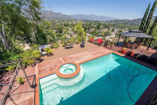 view of swimming pool featuring a gazebo, a mountain view, and an in ground hot tub