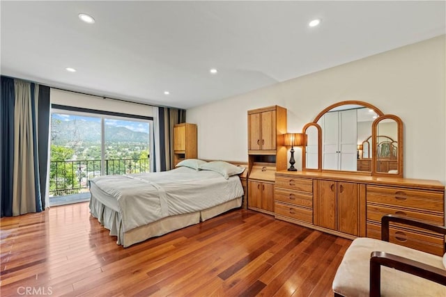 bedroom featuring wood-type flooring and access to outside