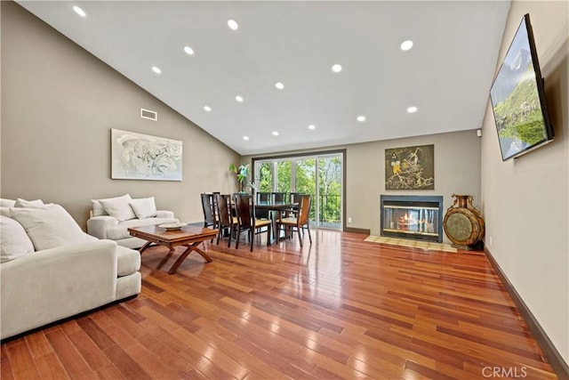 living room with light wood-type flooring and high vaulted ceiling