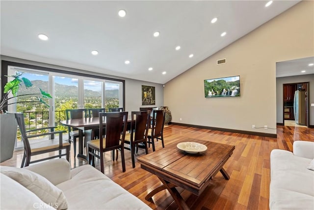 living room featuring high vaulted ceiling and light wood-type flooring