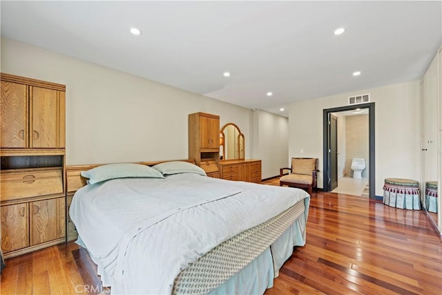 bedroom featuring hardwood / wood-style floors and ensuite bath