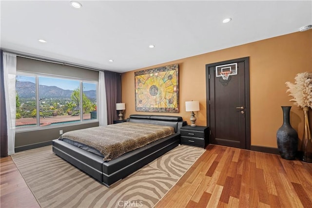 bedroom featuring a mountain view and light hardwood / wood-style floors