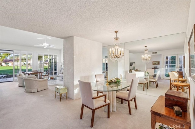 carpeted dining room with a textured ceiling and ceiling fan with notable chandelier