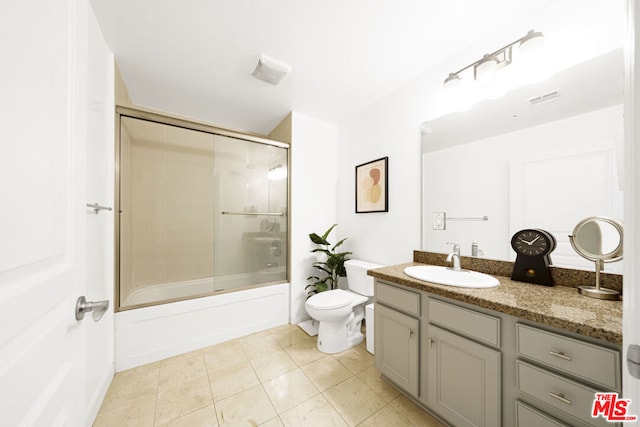 full bathroom featuring tile patterned flooring, vanity, toilet, and shower / bath combination with glass door