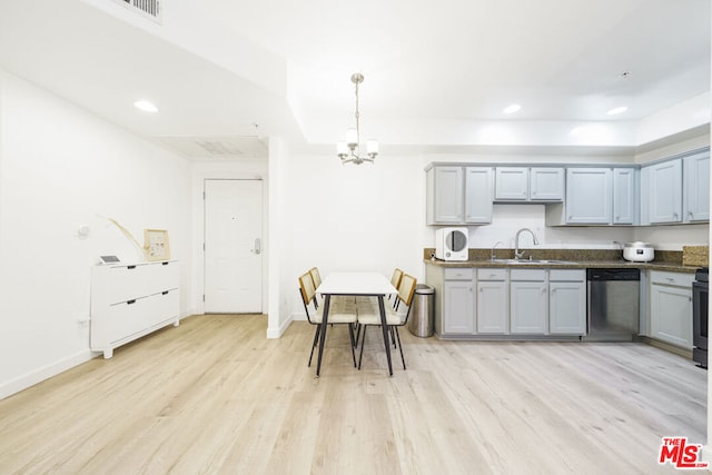 kitchen featuring pendant lighting, light hardwood / wood-style flooring, stainless steel dishwasher, and sink