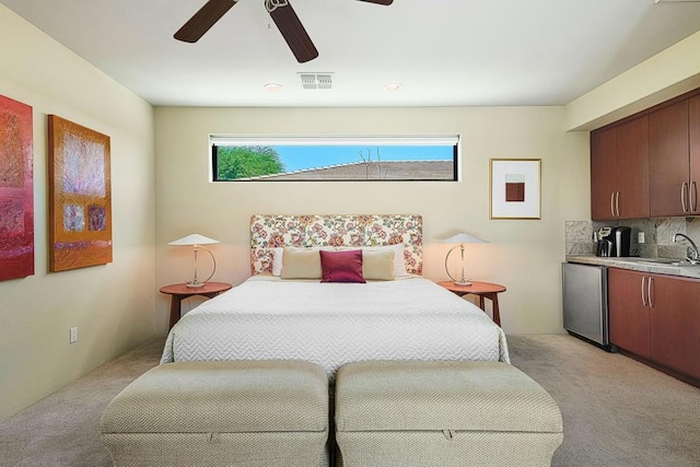 bedroom featuring stainless steel refrigerator, ceiling fan, and light colored carpet