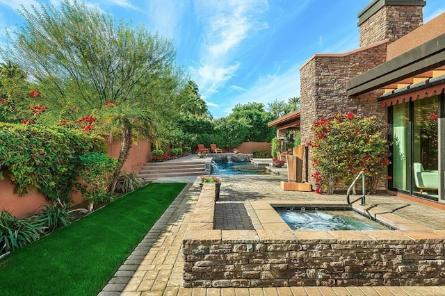 view of swimming pool with a patio area, an in ground hot tub, and pool water feature