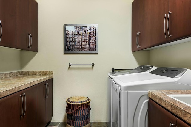 laundry room featuring washing machine and dryer and cabinets