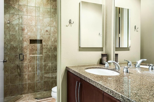 bathroom with toilet, vanity, and walk in shower