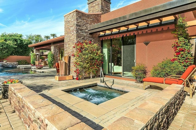 rear view of property with a swimming pool with hot tub and a patio