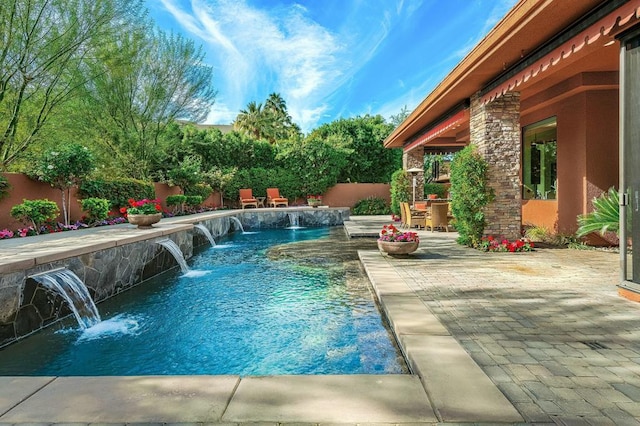 view of pool with pool water feature and a patio