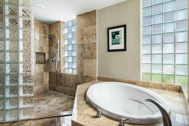 bathroom featuring a wealth of natural light and plus walk in shower