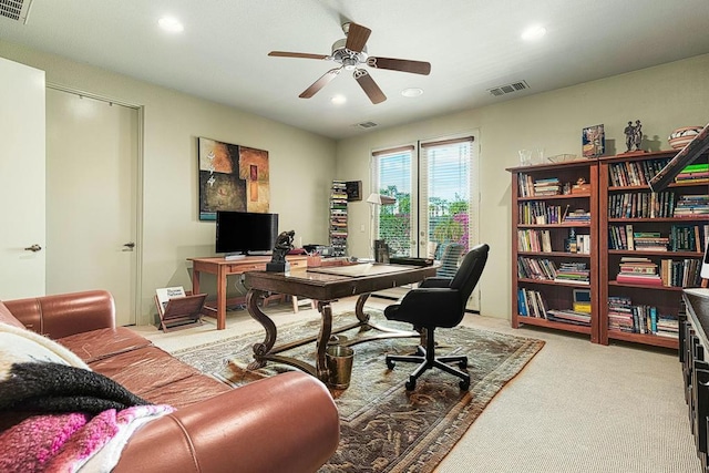 carpeted office space featuring ceiling fan