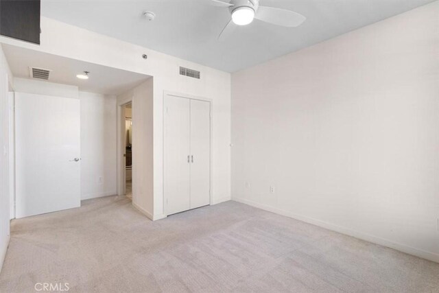 empty room featuring ceiling fan and light carpet