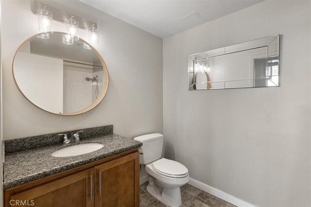 bathroom with toilet, vanity, and tile patterned flooring