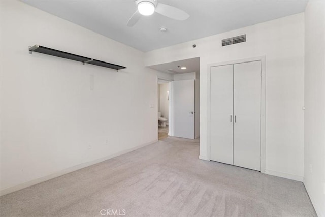 unfurnished bedroom with ceiling fan, a closet, and light colored carpet