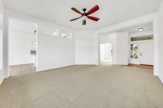 empty room with ceiling fan and light carpet