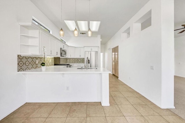 kitchen featuring white cabinetry, ceiling fan, hanging light fixtures, kitchen peninsula, and appliances with stainless steel finishes