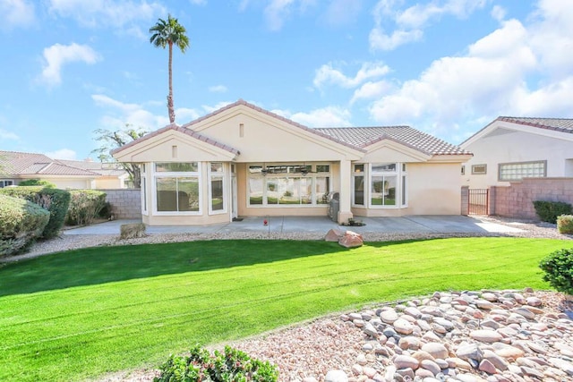 rear view of property featuring a yard and a patio