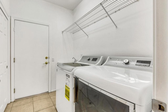 laundry room featuring separate washer and dryer and light tile patterned floors