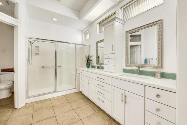 bathroom featuring tile patterned flooring, vanity, toilet, and a shower with door