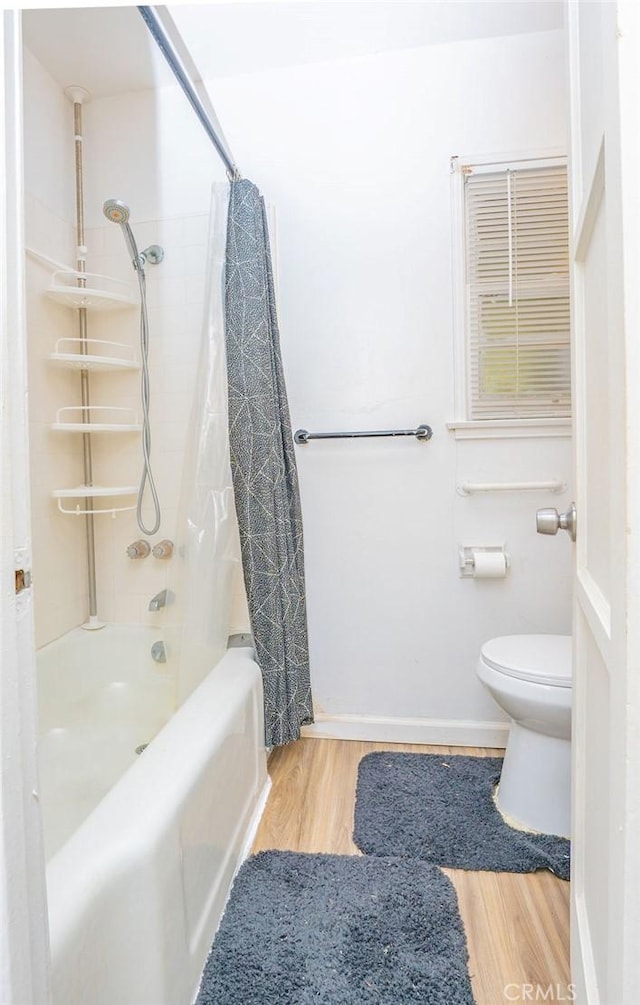 bathroom with wood-type flooring, toilet, and shower / bath combo with shower curtain