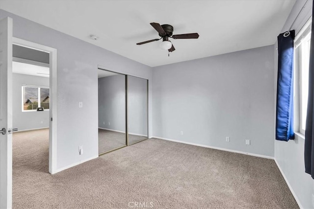 unfurnished bedroom with ceiling fan, carpet flooring, and a closet