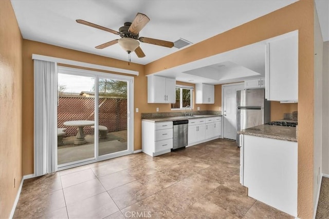 kitchen with white cabinetry, appliances with stainless steel finishes, sink, and light stone counters