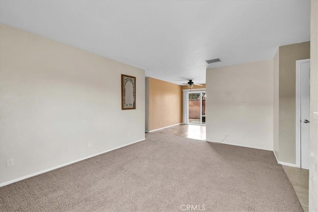 spare room featuring light carpet and ceiling fan