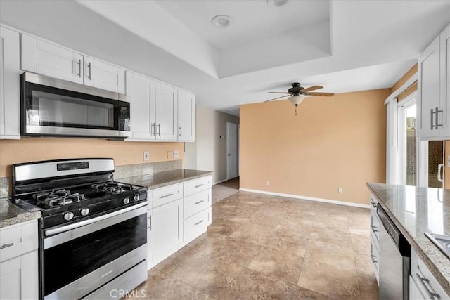 kitchen with white cabinetry, ceiling fan, appliances with stainless steel finishes, and a raised ceiling