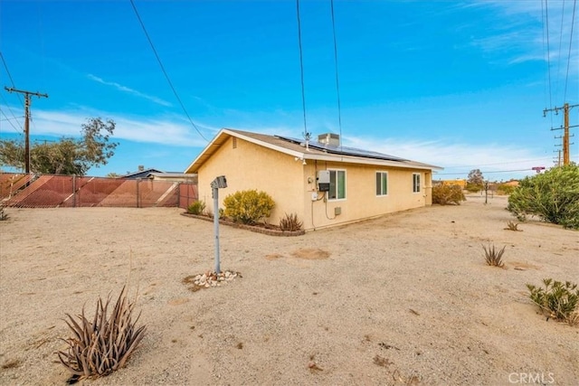 rear view of property featuring solar panels