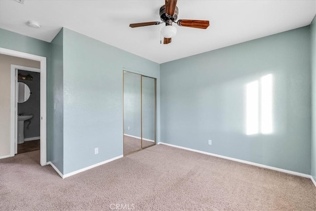 unfurnished bedroom featuring carpet, ceiling fan, and a closet