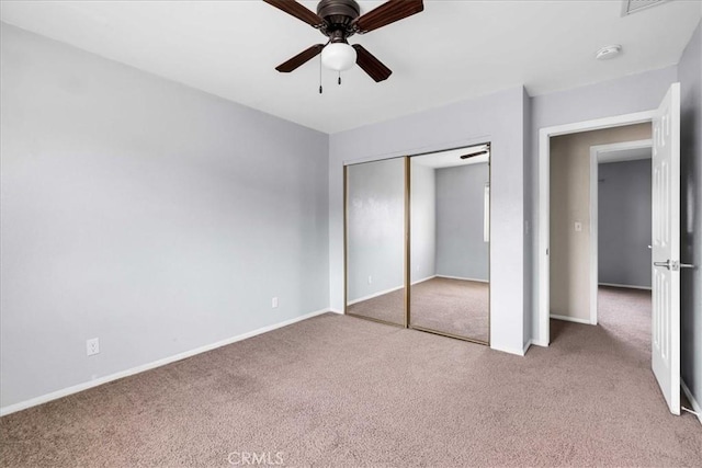 unfurnished bedroom with ceiling fan, light colored carpet, and a closet