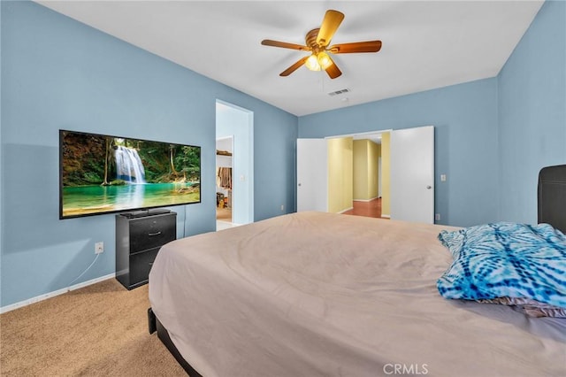 bedroom featuring ceiling fan, light carpet, and connected bathroom