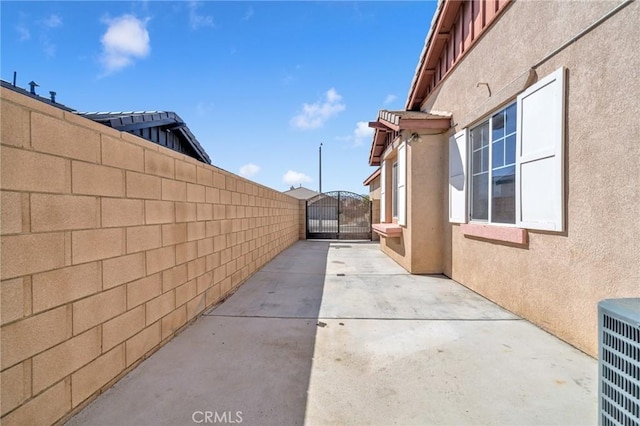 view of side of home with a patio and central AC