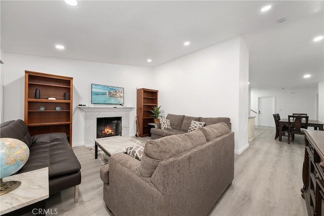 living room featuring a fireplace and light wood-type flooring