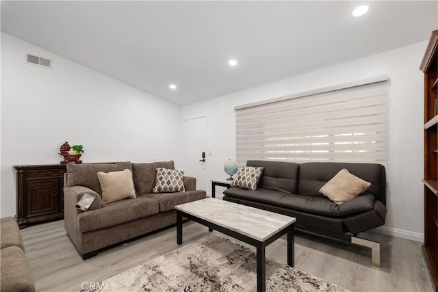 living room featuring vaulted ceiling and light hardwood / wood-style flooring