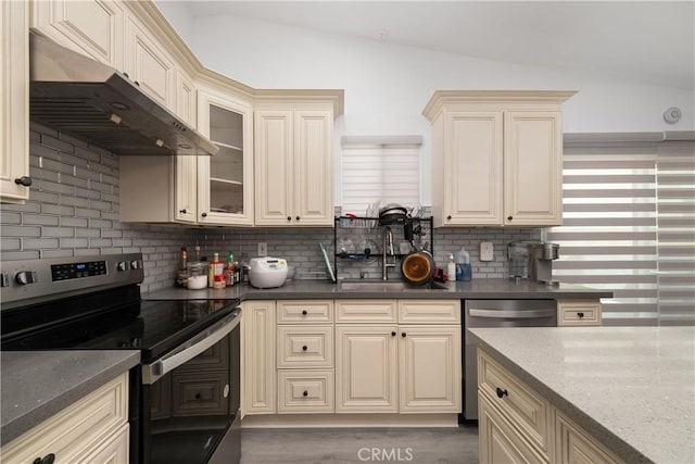 kitchen featuring cream cabinets, sink, lofted ceiling, and appliances with stainless steel finishes