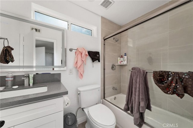 full bathroom with combined bath / shower with glass door, vanity, and toilet