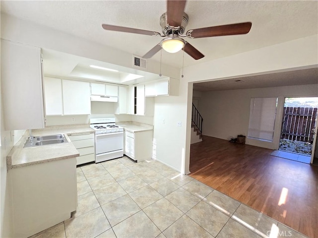 kitchen featuring white cabinets, white range, sink, light hardwood / wood-style flooring, and ceiling fan