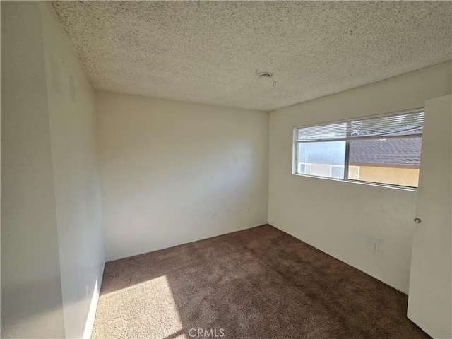 carpeted empty room featuring a textured ceiling