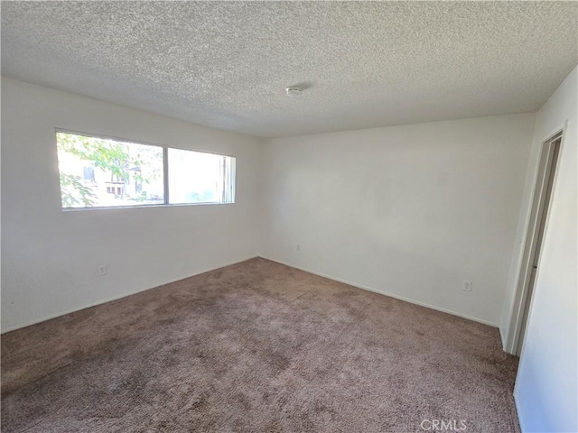 unfurnished room with a textured ceiling and carpet floors