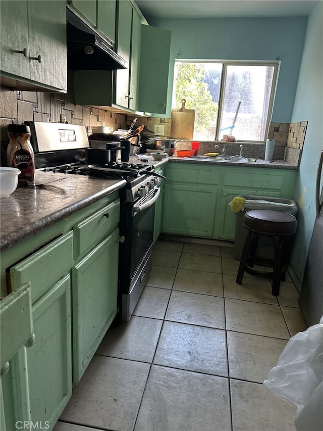 kitchen with gas stove, sink, backsplash, and green cabinetry